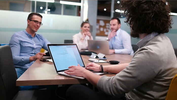 Man on Mac with colleagues